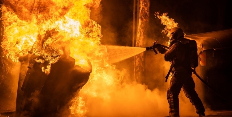 Un bomber apaga un incendi en un contenidor | Roger Benet